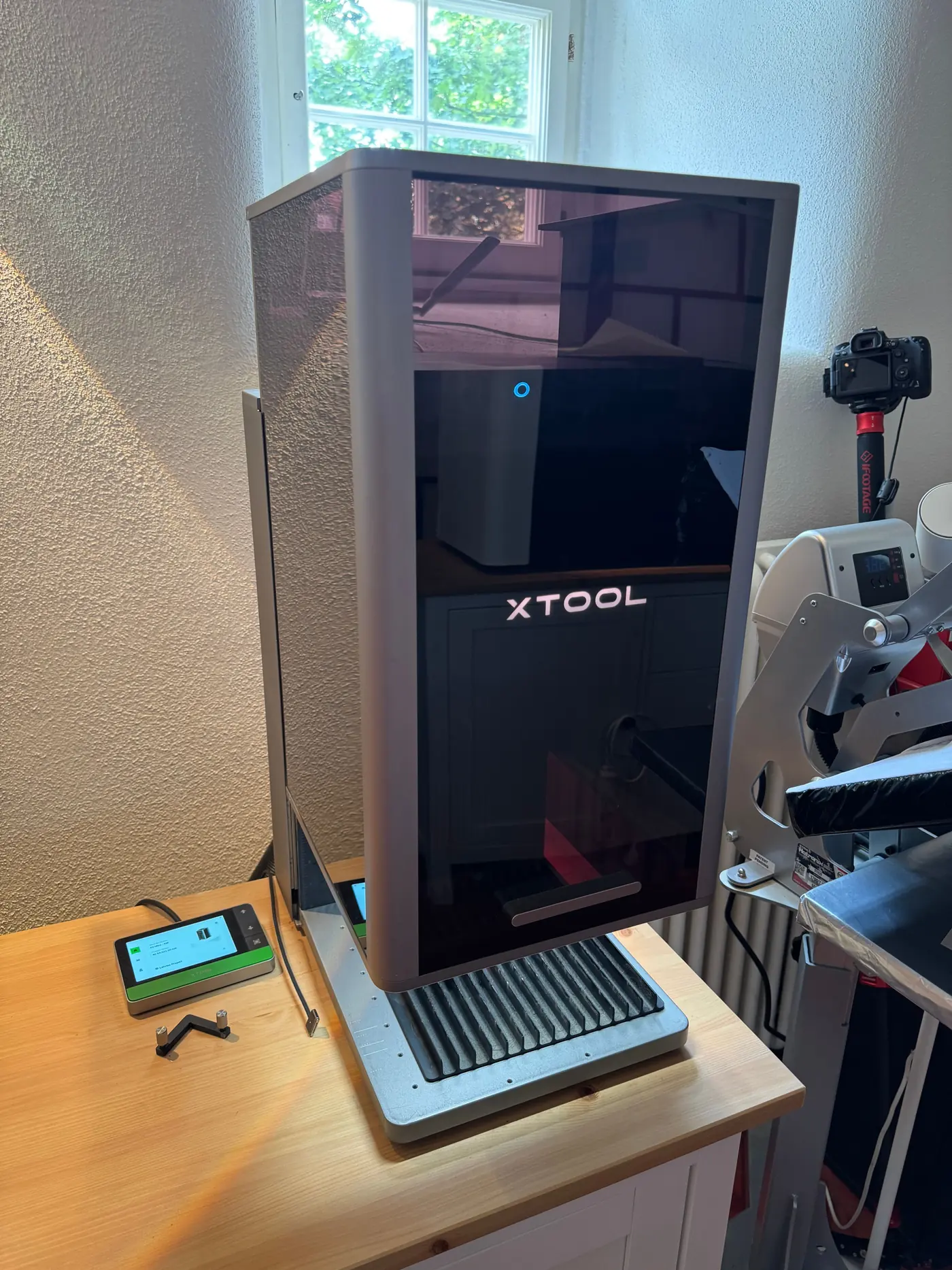 The xTool F2 Ultra head on: a dark tower on a wooden top, the control panel in front to the left, the honeycomb bed below.